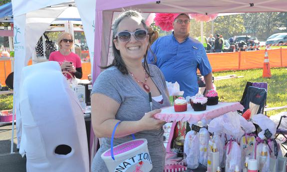 A volunteer handing out gifts and treats to people at the Unity Ride for Breast Cancer 