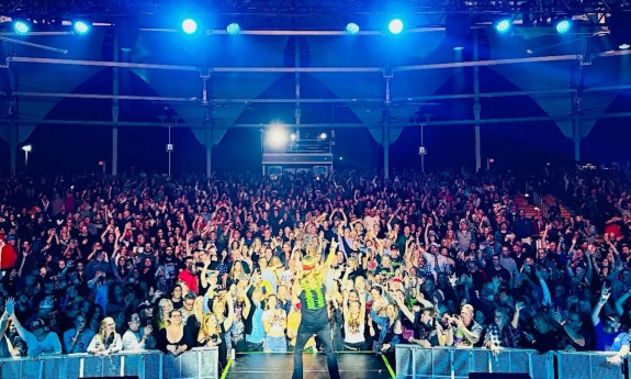 Bret Michaels lifts his hand high as he rocks the stage before a crowd of devoted fans.