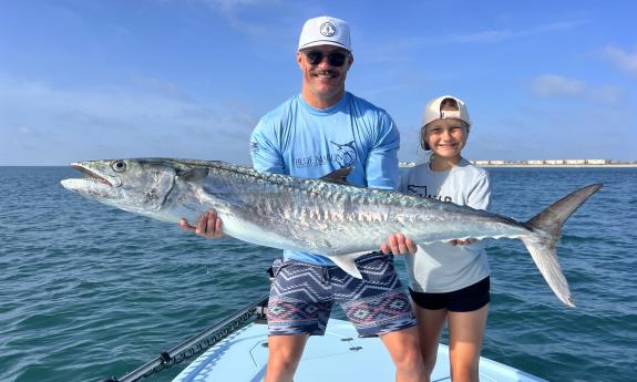 A fish being held up by anglers