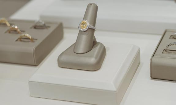 A yellow diamond ring in a display case