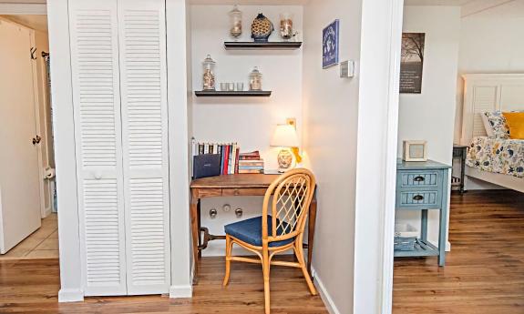 A desk nook, opposite the main living area and a view of a bedroom