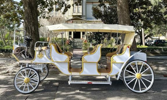 A white and gold horseless carriage replica electric vehicle