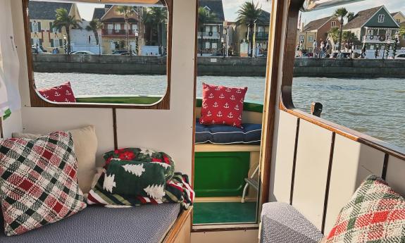 The cabin and aft deck of "Lady Augustine" a tiny tug, outfitted with warm, holiday decor