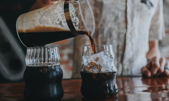 A server pouring coffee in glasses