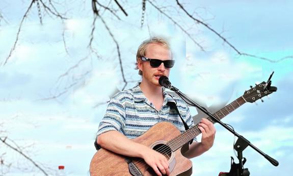 Tom Leighton onstage with his guitar, outside