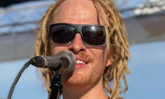 Tom Leighton behind a microphone, smiling