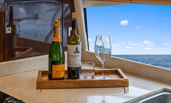 Beverage bottles and two glasses on a tray aboard L'Oceano