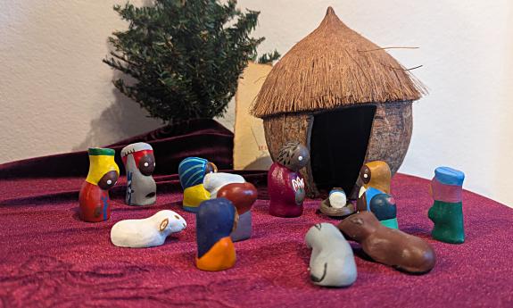 A folk-carving of the nativity depicted in Africa with a thatched hut