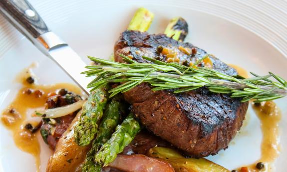A filet with sides, topped with a sprig of rosemary from River & Fort