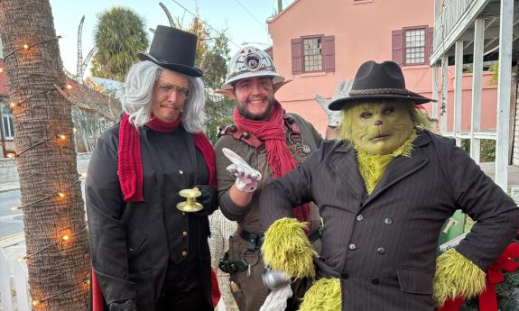Three characters from holiday tours standing outside