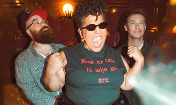 Members of Alabama Shakes stand together beneath warm, ambient lighting.
