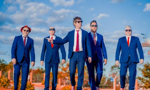 Bandmates from the Blues Beatles pose in blue suits with red ties.