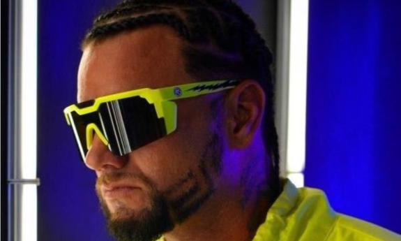 Riff Raff poses in yellow glasses and a matching shirt. 