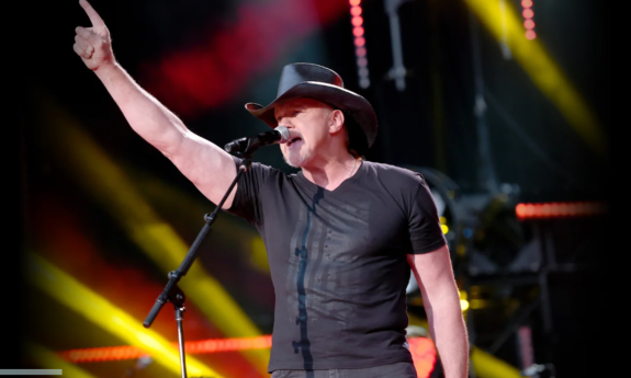 Trace Adkins dons a cowboy hat and performs on stage.