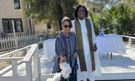  A minister, a dog owner, and her dog at a pet blessing event