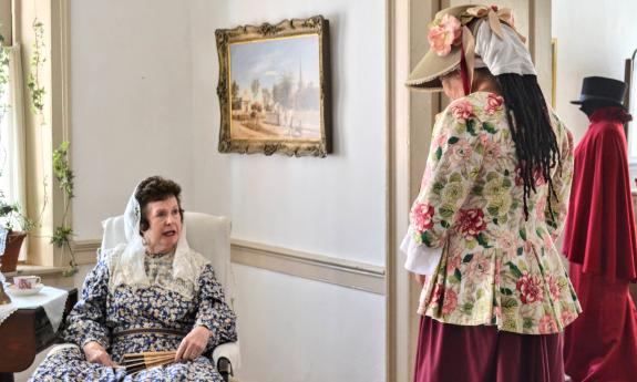 Two woment in peroid clothing in a boarding house