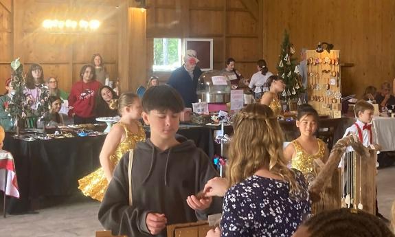 Young people selling their creations to others at a holiday market