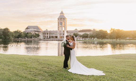 A bridal couple standing near the pond at The Legacy in World Golf Village