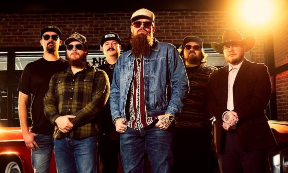 Bandmates from 49 Winchester pose in hats and dark sunglasses.