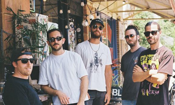 The band ajeva, standing on stage outside during the day