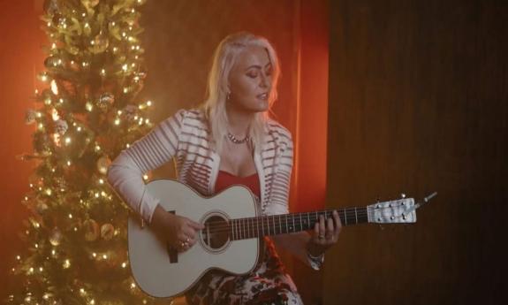 Songwriter Emma Zinck with guitar, onstage