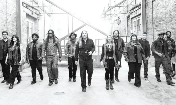 Bandmates from Tedeschi Trucks wear dark clothing and pose in a black-and-white photograph.