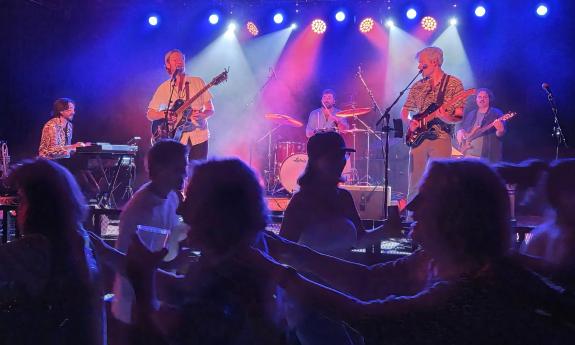 The band Jammy Buffet on stage with a standing and dancing crowd in front