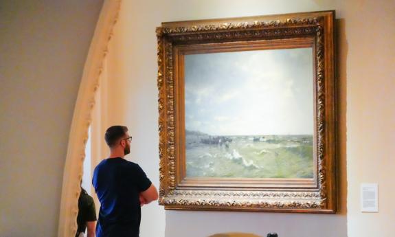 A man gazes at a painting hung in the Lightner Museum