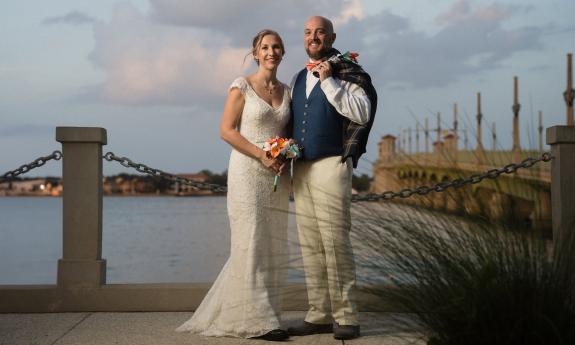 A wedded couple in front of the Bridge of Lions