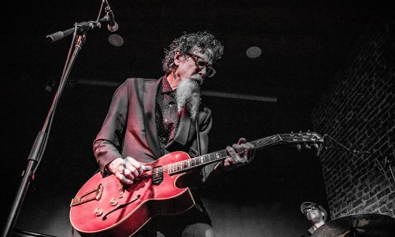 Walter Parks on stage with a red guitar