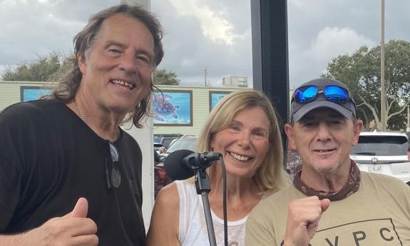 Carpetbaggers trio, standing outside, smiling