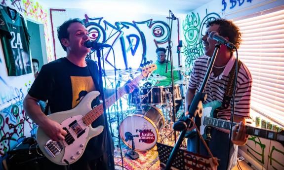 Bandmates from Pocket Knife Dance Party perform at a venue.