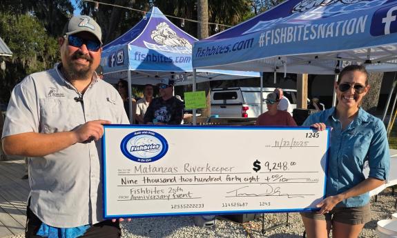 Two folks from the Matanzas Riverkeeper organization hold a check donated by Fishbites 