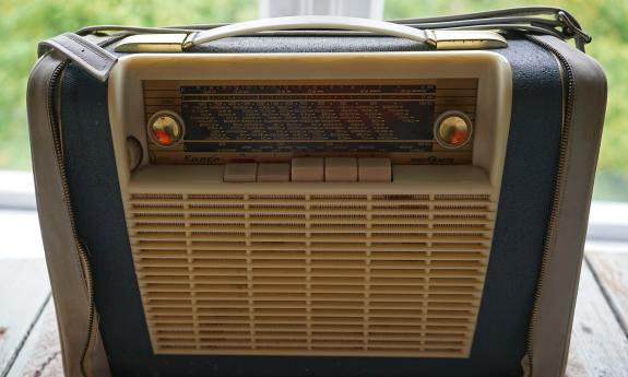 An old radio from the mid-century, on a picnic table 