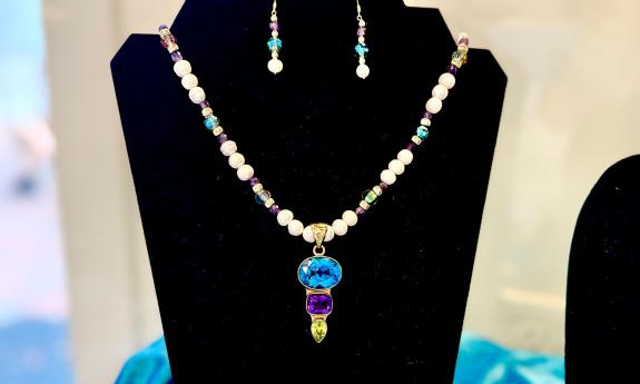 A necklace and earring set featuring pearls and semi-precious gems