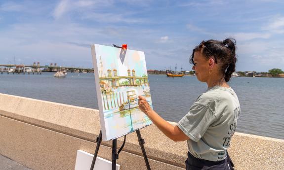 An artist painting the Bridge of Lions