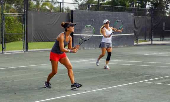 Two people on a doubles tennis team at The Yards