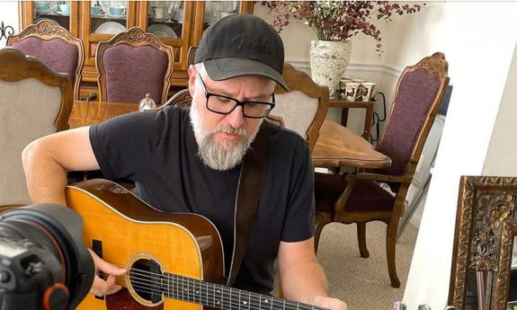 Songwroter Joey Kerr with his guitar, singing