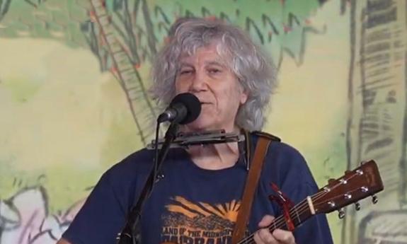 Singer songwriter novelist Rod MacDonald onstage with guitar