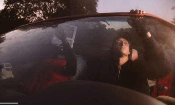 Stephen Wilson Jr. wears glasses and poses in his car.