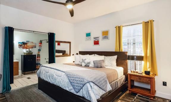 The Ashford guest room features gold and blue accents in a neurtral room