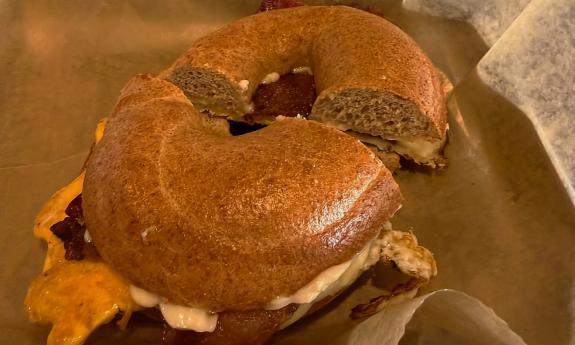 An egg, cheese, and bacon bagel sandwich
