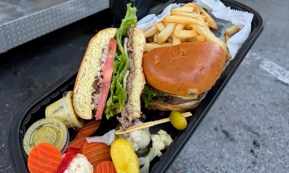 A tray of a burger with a side of fries