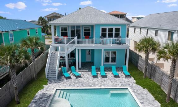 The back yard with pool, and the two outdoor lounge areas at an aqual-painted vacation home