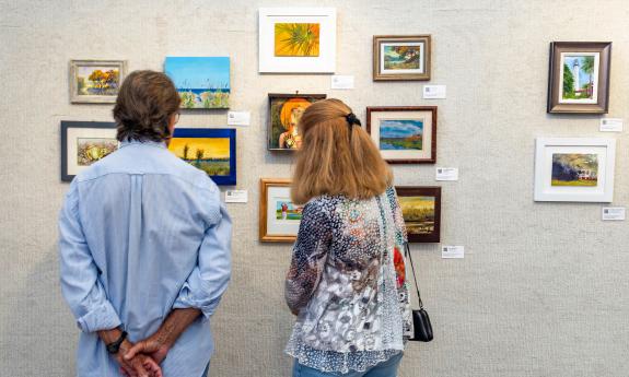 Two people looking at art on the wall