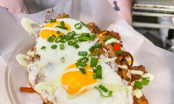 Two eggs over chorizo potatoes, and pepperts topped with hollandiase sauce