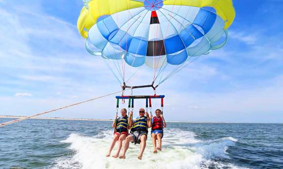 Two teens and an adult on a triple parasail ride