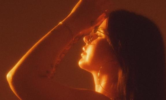 Caitlynne Jennings poses in front of a sepia backdrop.