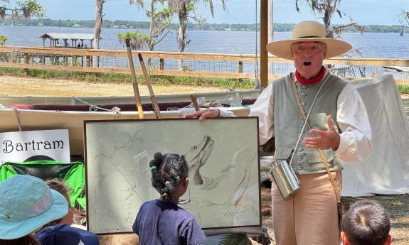 A reenactor protraying William Bartram, shows his art to kids