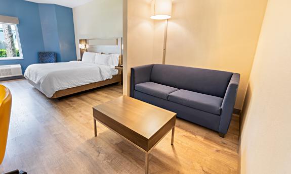 A room with a queen bed and sofa in a hotel in St. Augustine